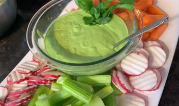 garlicky green tahini dip with fresh celery. baby carrots and radish chips